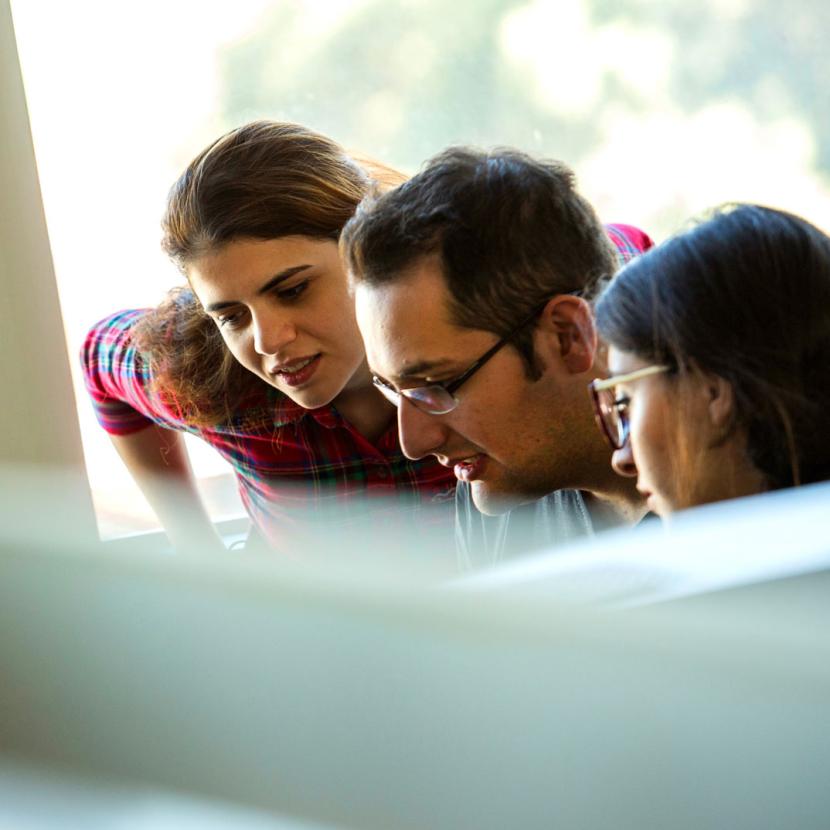 three students working on computer together