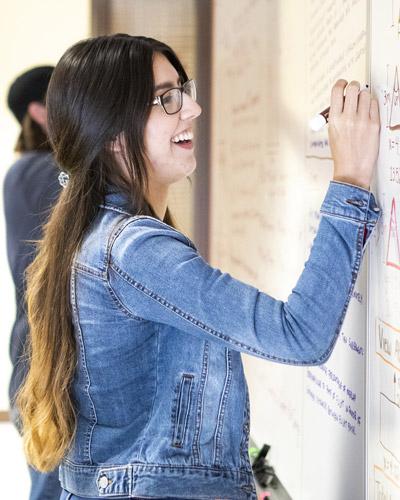 Female student writing on a white board